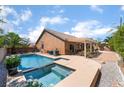 Back exterior view of the home featuring a sparkling pool, spa, and an inviting covered patio at 7559 Chambery Cove Ct, Las Vegas, NV 89123