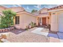 Inviting front entrance with desert landscaping, accent rocks, and a warm colored front door at 7909 Sierra Rim Dr, Las Vegas, NV 89131