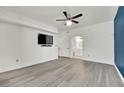 Spacious bedroom with ceiling fan and modern gray flooring, leading to a bathroom at 8408 White Eagle Ave # 101, Las Vegas, NV 89145