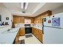 Functional kitchen featuring wood cabinets, white appliances, and ample counter space for meal preparation at 8450 Alta Dr # 225, Las Vegas, NV 89145