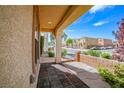 Brick accented, covered porch featuring open street view and landscaping, leading to the home's entrance at 9717 Villa Lorena Ave, Las Vegas, NV 89147