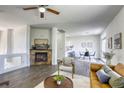 Open-concept living room with modern fireplace, stylish furniture, and adjacent dining area with natural light at 9966 Mystic Moss St, Las Vegas, NV 89183