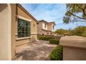 Charming home exterior features manicured landscaping, brick patio, and stucco walls at 12124 Kite Hill Ln, Las Vegas, NV 89138