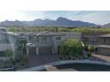 View of a modern home, surrounded by lush landscaping, featuring a mountain backdrop at 12428 Lincoln Creek Ave, Las Vegas, NV 89138