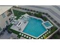 Aerial view of a luxurious pool with a spa, sun loungers, and a cozy outdoor seating area at 12428 Lincoln Creek Ave, Las Vegas, NV 89138