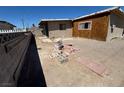Rear of property with exposed ground and construction materials, revealing a need for landscaping and finishing touches at 1908 Palmer St, North Las Vegas, NV 89030