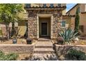 Inviting front entrance with stone columns, brick steps, and mature landscaping enhancing the home's appeal at 2116 Via Firenze, Henderson, NV 89044