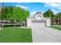 Well-maintained single-story home featuring a lush green lawn and a two-car garage at 240 Windsong Dr, Henderson, NV 89074
