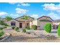 Single-story home with low maintenance desert landscaping with shrubs and trees lining the walkway to the front door at 2514 Tropical Sands Ave, North Las Vegas, NV 89031