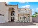 Home featuring a large arched entryway and balcony, white stucco, and an arched window at 2595 Aviv Ct, Las Vegas, NV 89121