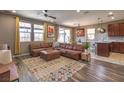 Open concept living area with modern decor, a large leather sectional sofa, and wood flooring at 2936 Aragon Terrace Way, Henderson, NV 89044