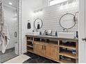 Modern bathroom featuring double sinks, patterned tile, and a glass-enclosed shower at 3024 Lotus Hill Dr, Las Vegas, NV 89134