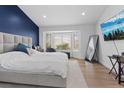 Bright bedroom featuring a bay window, hardwood floors, and a blue accent wall at 3024 Lotus Hill Dr, Las Vegas, NV 89134