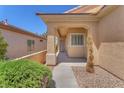 Inviting covered front porch and walkway leading to the entrance of the home with mature landscaping at 3056 Monroe Park Rd, Henderson, NV 89052