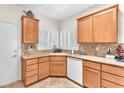 Well-lit kitchen boasts stone countertops, wood cabinetry, stainless steel sink, and white plantation shutters at 3056 Monroe Park Rd, Henderson, NV 89052