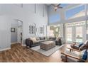 Spacious living room with high ceilings, wood floors, a gray sofa and access to outdoor pool area at 3079 Paseo Mountain Ave, Henderson, NV 89052