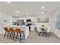 Bright, airy kitchen with stainless steel appliances, quartz countertops, island with seating, and a dining area at 3762 Sonrisa Vista Ave, Henderson, NV 89044