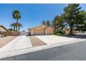 Single-story home featuring a two-car garage, palm trees, mature shade trees and gravel landscaping at 4004 Nancy Margarite Ln, Las Vegas, NV 89130