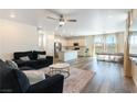 Open-concept living room with modern furniture, wood floors, and abundant natural light at 4517 Swimming Minnow Ave, Las Vegas, NV 89141