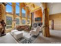 Stunning log home living room featuring floor-to-ceiling windows, fireplace, and exposed wood beams at 4927 Snow White Rd, Las Vegas, NV 89124