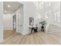 Bright foyer with light wood floors, a modern staircase, and stylish console table at 4944 Spanish Heights Dr, Las Vegas, NV 89148