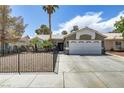 This exterior view showcases the front of a well-kept home with desert landscaping and fenced yard at 5045 Sock Hop Way, North Las Vegas, NV 89031