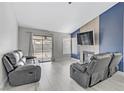 Comfortable living room boasts a fireplace, large windows, and stylish, neutral tones at 5045 Sock Hop Way, North Las Vegas, NV 89031