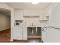 Bright kitchen with white cabinets and appliances and wood look flooring at 555 Highland Dr # 203, Mesquite, NV 89027