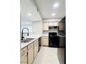 Functional kitchen features modern sink faucet, black appliances and light cabinets at 8101 W Flamingo Rd # 1088, Las Vegas, NV 89147