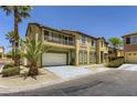 Two-story tan home with a balcony, desert landscaping and a two car garage at 8143 Retriever Ave, Las Vegas, NV 89147