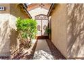A decorative wrought-iron gate leads to the entrance of the home, surrounded by desert landscaping at 9048 Faversham Ct, Las Vegas, NV 89123