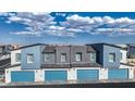 Rear aerial view of townhomes featuring attached garages and coordinated color schemes against a blue sky at 9330 Soothing Sea St # Lot 92, Las Vegas, NV 89178