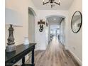 Elegant entryway with dark wood floors, decorative mirror, and decorative welcome sign on wall at 10456 Skye Arroyo Ave, Las Vegas, NV 89166