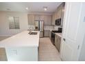 Well-equipped kitchen with gray cabinets, white countertops, and stainless steel appliances at 12101 Arrebol Ave, Las Vegas, NV 89138