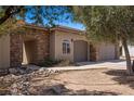 Beautiful home exterior showcasing a stone accent wall, three-car garage, and drought-tolerant landscaping at 1981 Trophy Elk Ave, Logandale, NV 89021