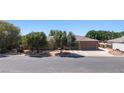 Spacious single-story home featuring a three-car garage, mature trees, and a well-maintained front yard at 1981 Trophy Elk Ave, Logandale, NV 89021