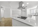 Bright kitchen featuring an island with cooktop, stainless steel vent hood, and tile flooring at 2080 Karen Ave # 60, Las Vegas, NV 89169