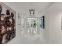 Hallway featuring white tile floors, modern lighting, and elegant artwork, leading to a comfortable living space at 2857 Paradise Rd # 305, Las Vegas, NV 89109