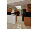 Well-lit kitchen boasts wood cabinets, black countertops, and modern appliances at 3104 Archwood Way, Las Vegas, NV 89134