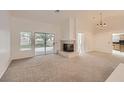 Bright living room with a cozy fireplace, sliding glass doors, and views of the backyard at 3104 Archwood Way, Las Vegas, NV 89134