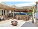 Outdoor bar with a tiki theme, complete with a thatched roof, seating, and a decorative backdrop at 603 Fiddlehead Ave, Las Vegas, NV 89183
