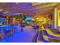 Inviting outdoor patio featuring a covered seating area, bar with lighting, and dining space at 603 Fiddlehead Ave, Las Vegas, NV 89183