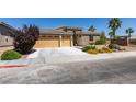 Single-story home featuring a well-manicured lawn, desert landscaping, and a three-car garage at 768 Flowing Meadow Dr, Henderson, NV 89014