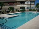 Large, sparkling community swimming pool with lounge chairs and manicured landscaping at 833 Aspen Peak Loop # 2511, Henderson, NV 89011