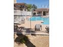 Community pool with sun loungers, partially visible through a white fence, inviting relaxation at 833 Aspen Peak Loop # 2511, Henderson, NV 89011