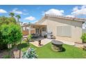 Inviting backyard with a covered patio, outdoor seating, grill, artificial grass, and cozy fire pit at 851 Offerman Ave, Las Vegas, NV 89123