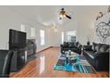 Bright living room featuring a fireplace, ceiling fan, hardwood floors, and comfortable leather sofas at 851 Offerman Ave, Las Vegas, NV 89123