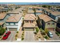 An aerial view showcases the property with a two-car garage and desert landscaping in a quiet neighborhood at 10352 Rye Patch Creek St, Las Vegas, NV 89141