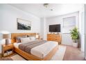 Modern main bedroom with natural wood furniture and decor, and a large window at 110 Wynntry Dr, Henderson, NV 89074