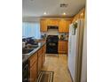 The kitchen features oak cabinets, a black oven range and white refrigerator at 1169 Paradise River Rd, Henderson, NV 89002